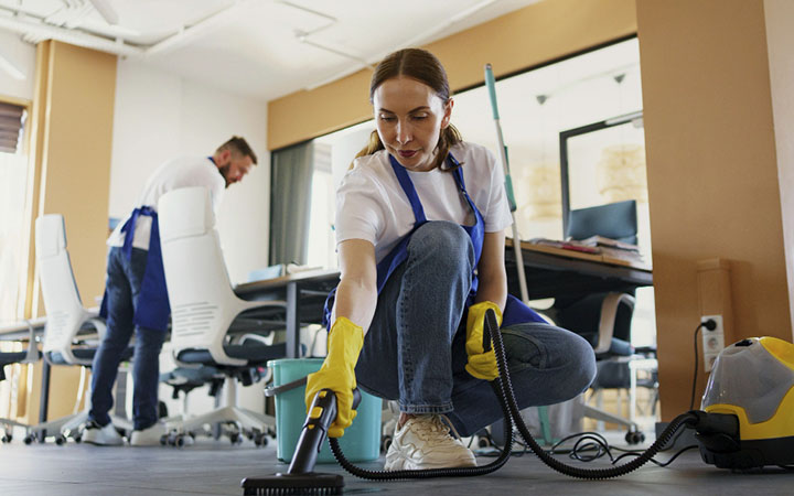 limpeza_0000_pessoa-de-servico-de-limpeza-profissional-usando-aspirador-de-po-no-escritorio-1