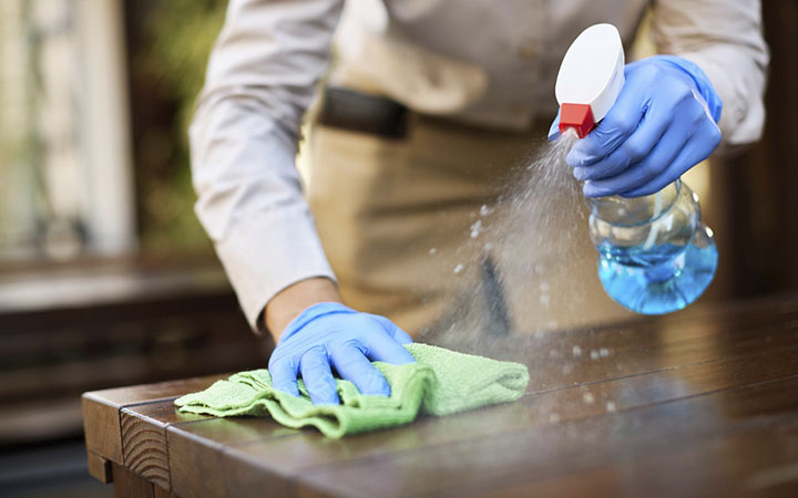 limpeza_0001_closeup-de-garconete-desinfetando-mesas-no-cafe-ao-ar-livre